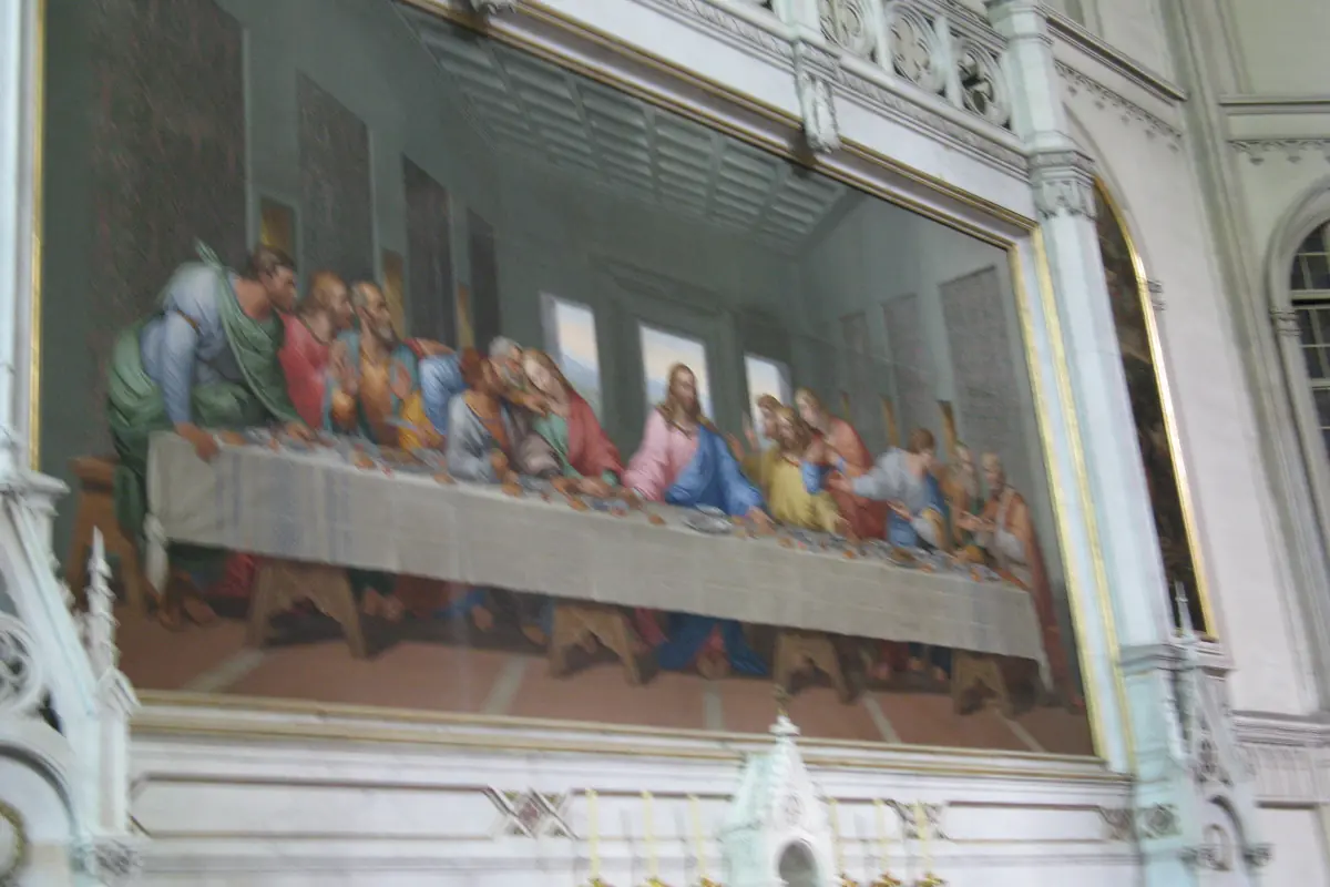 The large mosaic copy of The Last Supper on the wall of the Minoritenkirche, set in a pale Gothic-style frame beside white stonework