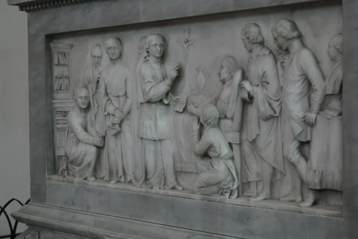 A marble relief on the Metastasio monument in the Minoritenkirche showing a group of standing and kneeling figures around a central figure